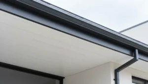 Jak zrobić podbitkę dachową poradnik 2026 białe panele PCV z kratkami wentylacyjnymi pod okapem nowoczesnego domu